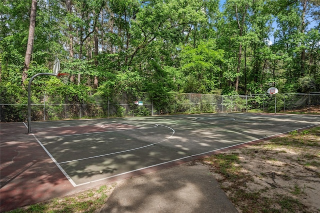 view of basketball court featuring basketball court and fence