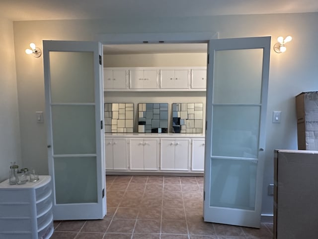 kitchen featuring white cabinetry and dark tile patterned flooring