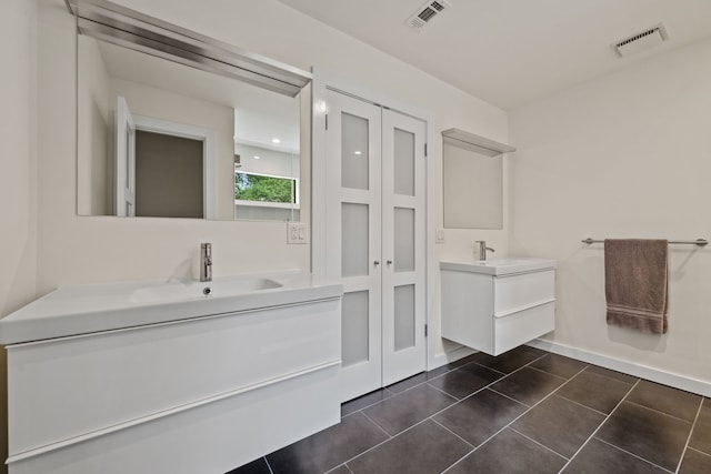 full bathroom with two vanities, visible vents, tile patterned flooring, and a sink