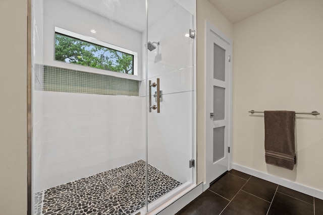 full bathroom with tile patterned flooring, a stall shower, and baseboards