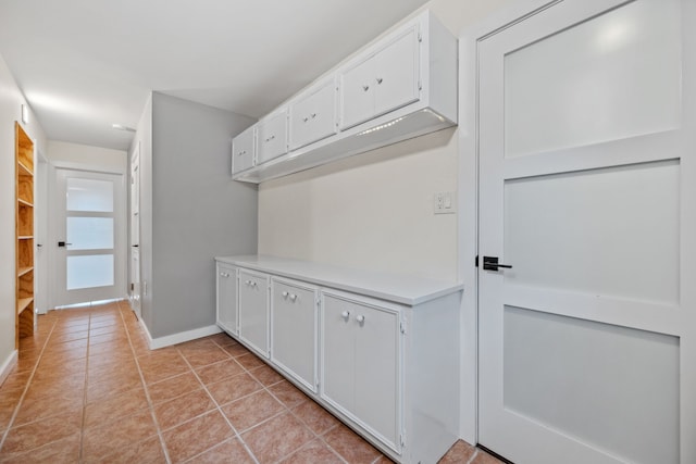 interior space with light tile patterned flooring and baseboards