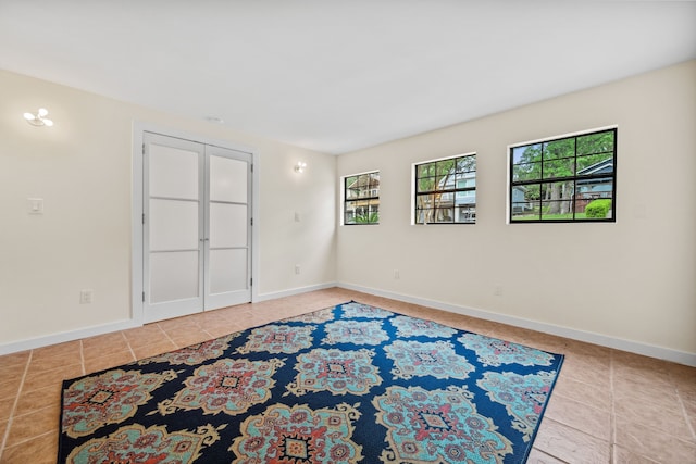unfurnished room with tile patterned floors and baseboards