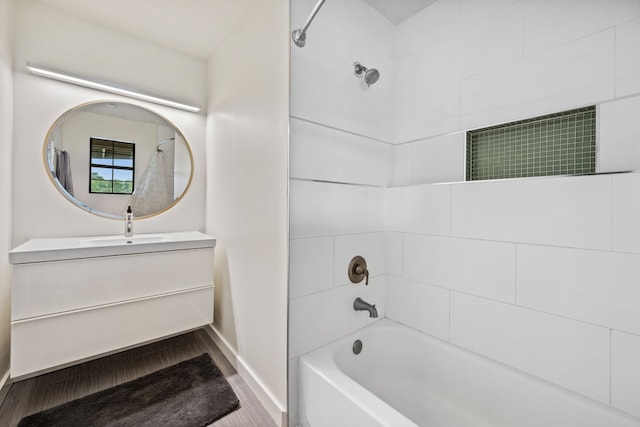full bathroom with vanity, washtub / shower combination, wood finished floors, and baseboards
