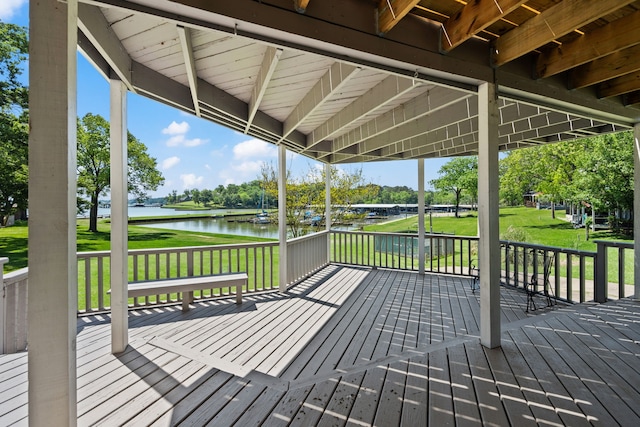 wooden terrace with a yard and a water view