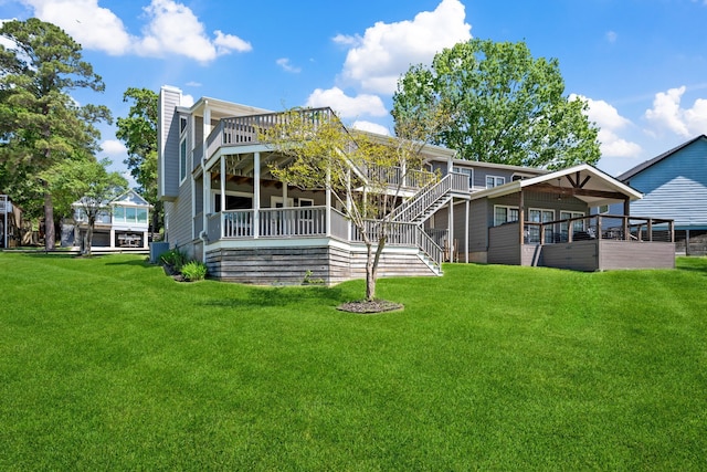 rear view of property featuring a lawn, stairs, a wooden deck, and a chimney