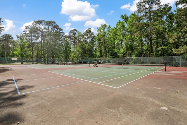 view of tennis court featuring fence and community basketball court