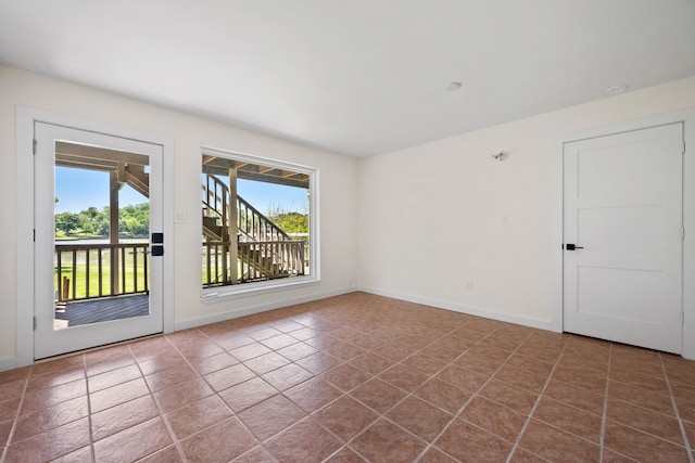 unfurnished room with tile patterned flooring and baseboards