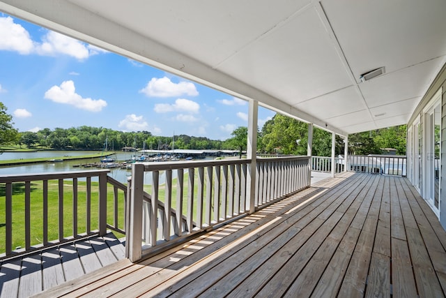 wooden terrace featuring a yard and a water view