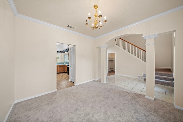 unfurnished living room with visible vents, arched walkways, ornate columns, and carpet floors