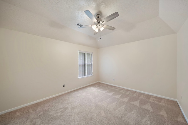 spare room featuring light colored carpet, ceiling fan, baseboards, visible vents, and lofted ceiling