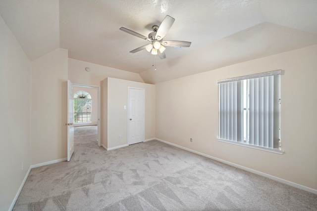unfurnished bedroom featuring carpet flooring, vaulted ceiling, and baseboards