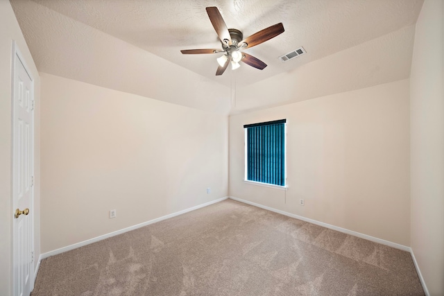 carpeted spare room with a textured ceiling, ceiling fan, visible vents, and baseboards