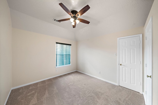 empty room featuring carpet flooring, visible vents, ceiling fan, and baseboards
