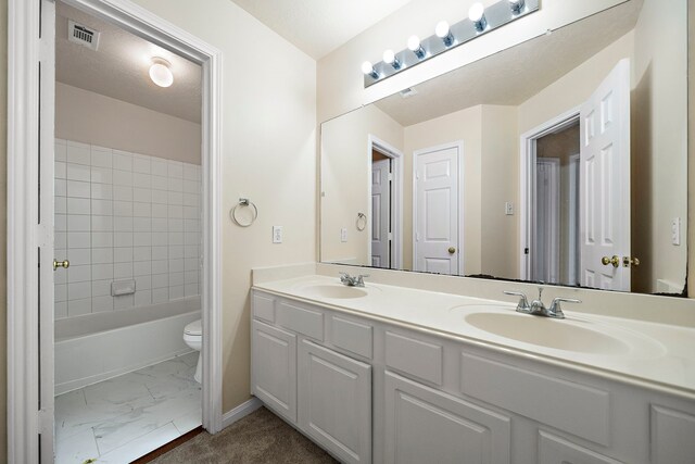 full bath featuring toilet, marble finish floor, a sink, and visible vents