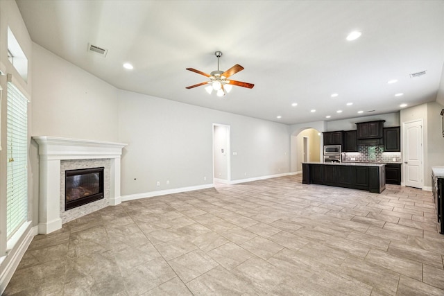 unfurnished living room with visible vents, recessed lighting, ceiling fan, and a glass covered fireplace