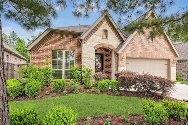 view of front facade featuring stone siding, driveway, brick siding, and a garage
