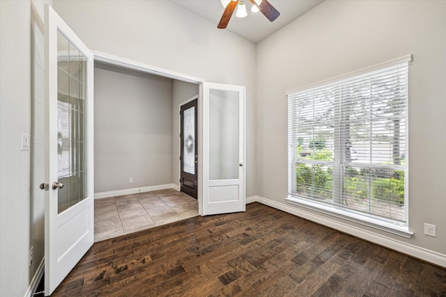 spare room with dark wood-type flooring, french doors, and ceiling fan