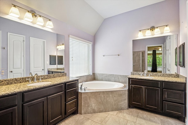 bathroom with a garden tub, two vanities, a sink, and a shower stall