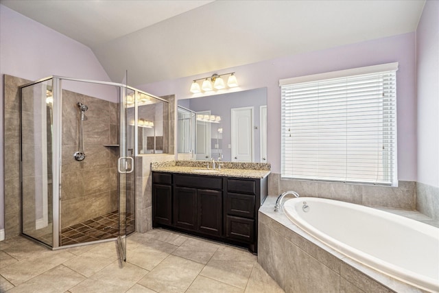 full bathroom with tile patterned floors, vaulted ceiling, vanity, a stall shower, and a garden tub