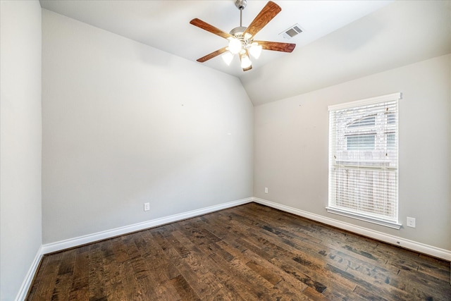 empty room with lofted ceiling, visible vents, baseboards, dark wood-type flooring, and a ceiling fan