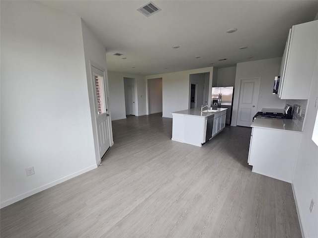 kitchen featuring open floor plan, visible vents, wood finished floors, and light countertops