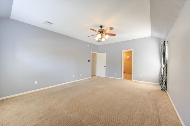 unfurnished bedroom with ceiling fan, visible vents, vaulted ceiling, baseboards, and light colored carpet