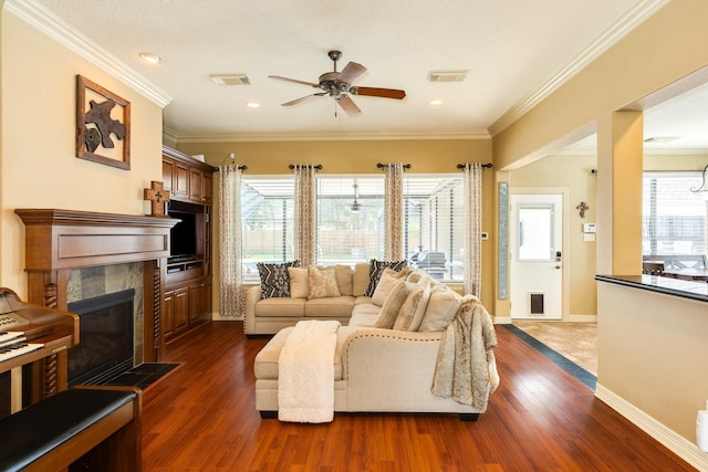 living area featuring a ceiling fan, visible vents, a healthy amount of sunlight, and baseboards