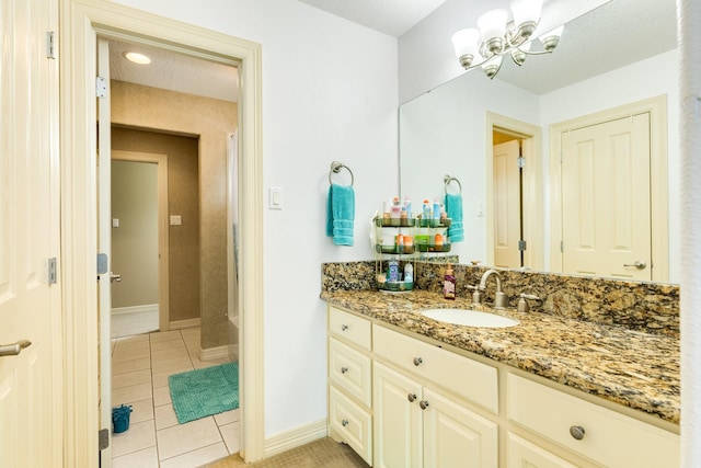 full bath with baseboards, an inviting chandelier, tile patterned flooring, and vanity