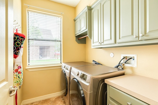 laundry area with light tile patterned floors, washing machine and clothes dryer, cabinet space, and baseboards