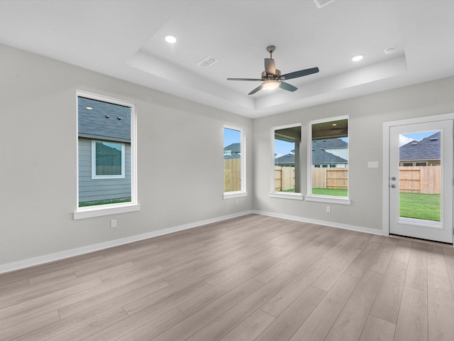 21711 White Bellflower Ln, Cypress, TX 77433 - empty room featuring a tray ceiling, light wood-type flooring, a ceiling fan, and recessed lighting
