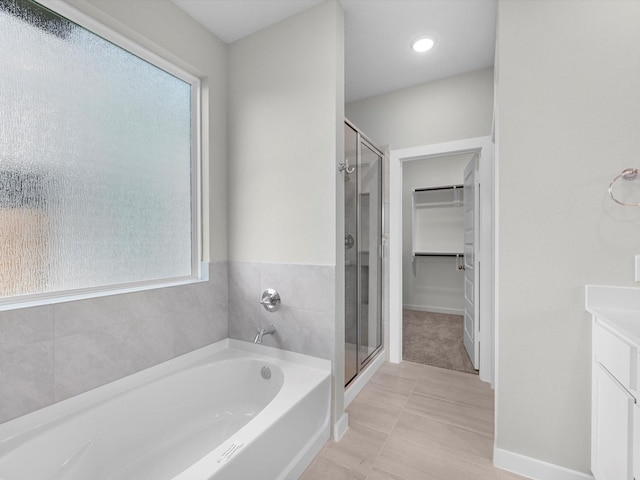 21711 White Bellflower Ln, Cypress, TX 77433 - bathroom with a shower stall, a garden tub, a spacious closet, tile patterned flooring, and vanity