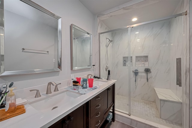 full bathroom with double vanity, recessed lighting, a marble finish shower, and a sink