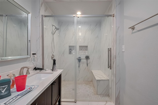 bathroom featuring a marble finish shower and vanity