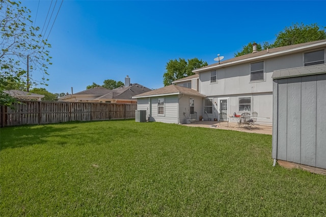 rear view of house with fence, a lawn, central air condition unit, and a patio