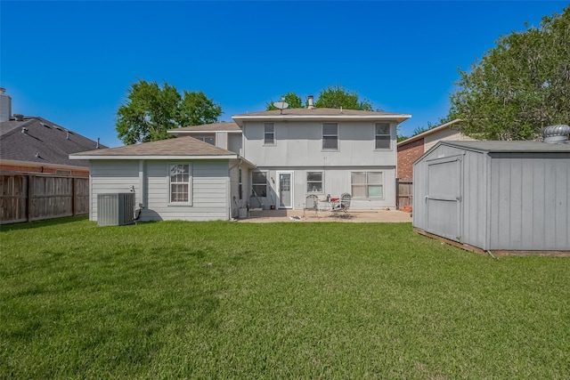 back of house featuring a storage shed, a patio, an outdoor structure, and a yard