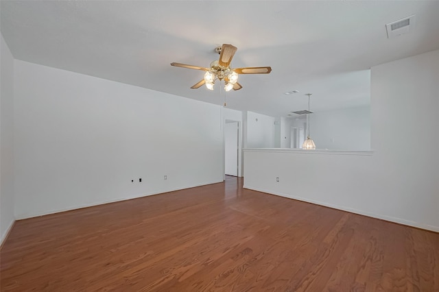spare room featuring visible vents, ceiling fan, wood finished floors, and baseboards