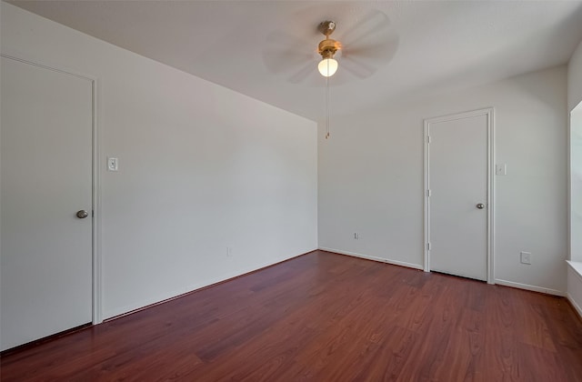 spare room with baseboards, wood finished floors, and a ceiling fan