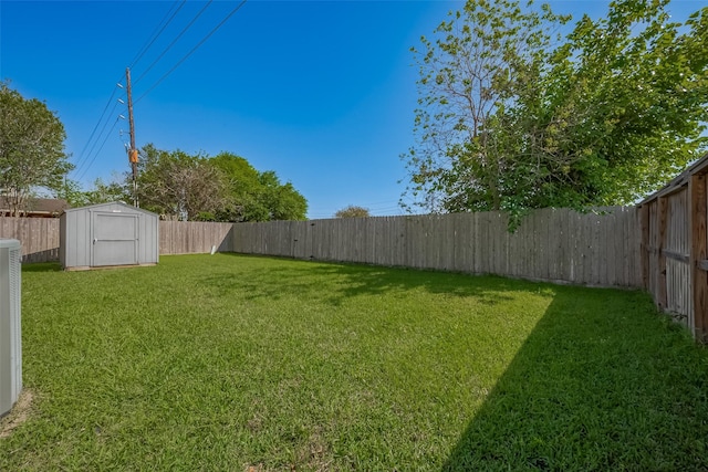 view of yard featuring an outbuilding, a storage shed, and a fenced backyard