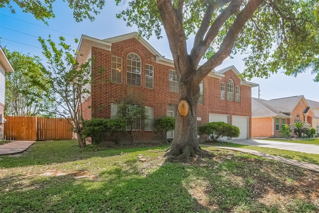 traditional home featuring brick siding, fence, driveway, and an attached garage