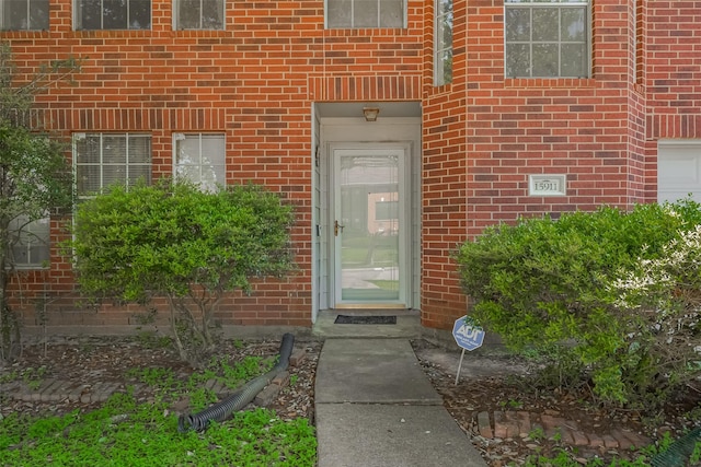 view of exterior entry featuring brick siding