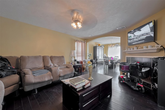 living room featuring visible vents, dark wood-style floors, and arched walkways