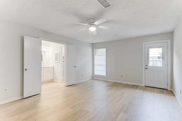 spare room with a ceiling fan, baseboards, and a healthy amount of sunlight