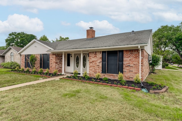 ranch-style house featuring a chimney, brick siding, a front lawn, and roof with shingles