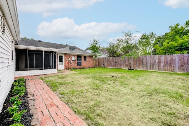 view of yard with a sunroom and a fenced backyard