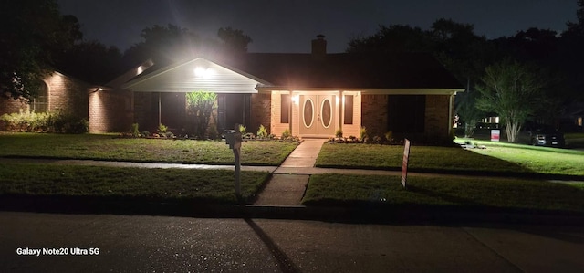 view of front of house with a lawn and a chimney