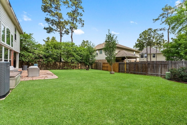 view of yard with a fenced backyard, a patio, and central air condition unit