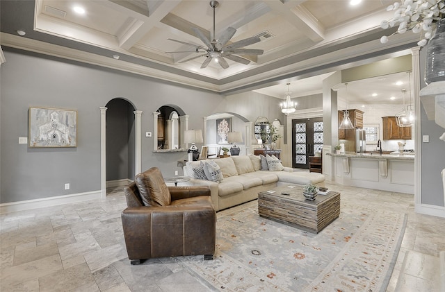 living room with a ceiling fan, a towering ceiling, arched walkways, coffered ceiling, and stone tile floors