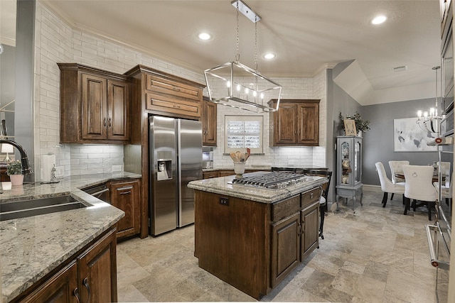 1330 Royal Sands Ln, Houston, TX 77345 - kitchen featuring appliances with stainless steel finishes, a chandelier, a sink, decorative backsplash, and light stone counters