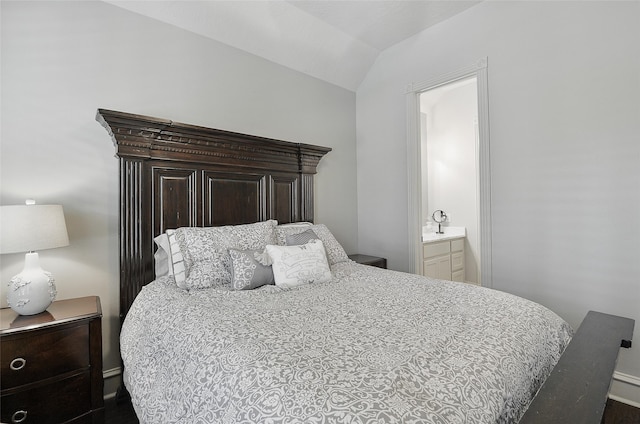 bedroom featuring connected bathroom and lofted ceiling