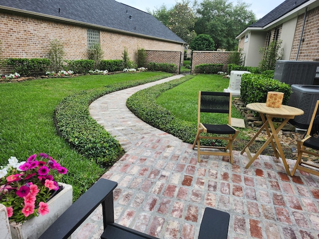 view of yard featuring fence, central AC unit, and a patio